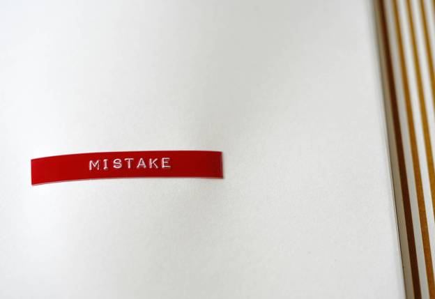 Rode sticker met de tekst 'mistake' op een onduidelijke ondergrond.
