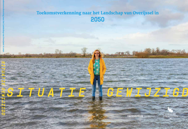 Een vrouw in een gele jas en laarzen staat in ondiep, overstroomd land met een open landschap en bomen op de achtergrond. De lucht is deels bewolkt. De afbeelding bevat de titel Situatie Gewijzigd en verwijst naar een toekomstverkenning van het landschap in Overijssel in 2050.