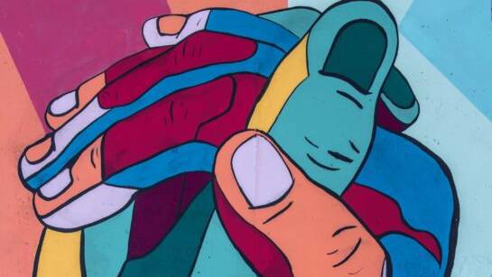 Twee getekende kleurrijke handen die elkaar vasthouden