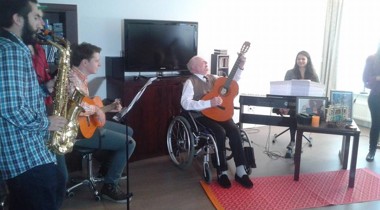 Een groep mensen maakt samen muziek in een woonkamer.