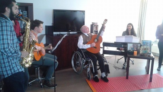 Een groep mensen maakt samen muziek in een woonkamer.