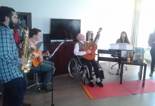 Een groep mensen maakt samen muziek in een woonkamer.