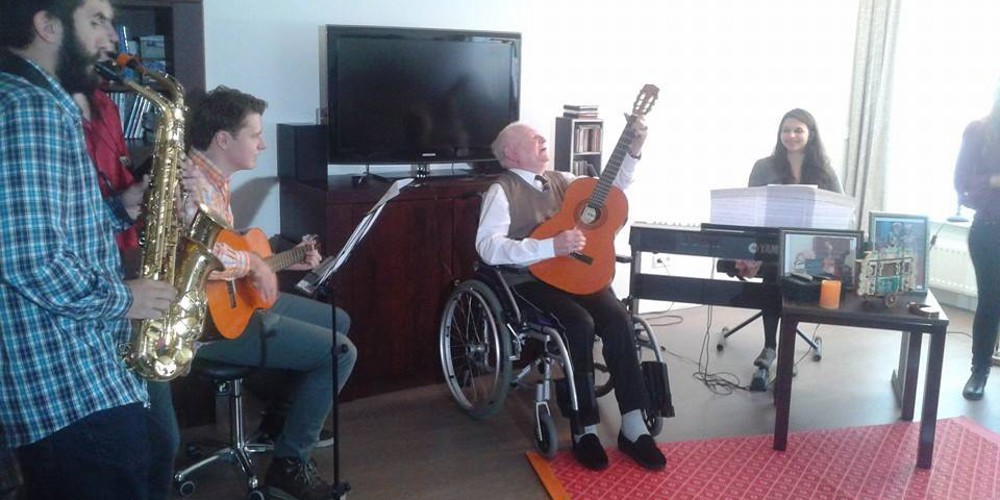 Een groep mensen maakt samen muziek in een woonkamer.