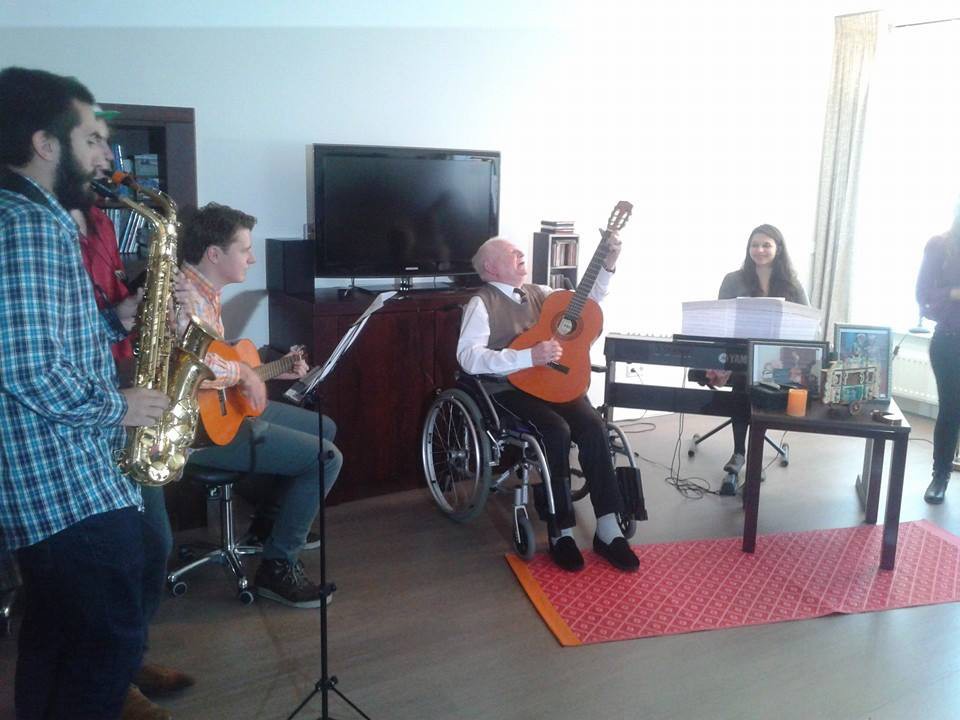 Een groep mensen maakt samen muziek in een woonkamer.